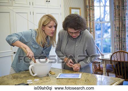 Senior woman and granddaughter baking and using digital tablet View Large Photo Image Stock Image - Senior woman and granddaughter baking and using digital tablet. Fotosearch