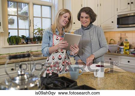 Senior woman and granddaughter checking recipe on digital tablet View Large Photo Image Stock Photo - Senior woman and granddaughter checking recipe on digital tablet. Fotosearch