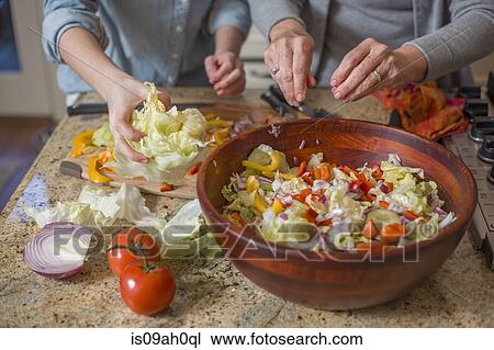 Senior woman and granddaughter chopping vegetables for salad View Large Photo Image Stock Image - Senior woman and granddaughter chopping vegetables for salad. Fotosearch