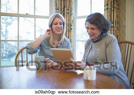 Senior woman and granddaughter looking at digital tablet View Large Photo Image Stock Photography - Senior woman and granddaughter looking at digital tablet. Fotosearch