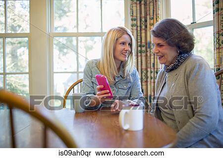Stock Photography - Senior woman and granddaughter looking at smartphone. Fotosearch