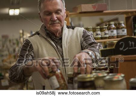 Shop keeper arranging jars in shop View Large Photo Image Stock Image - Shop keeper arranging jars in shop. Fotosearch