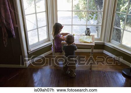 Stock Image - Sister and brother playing indoors. Fotosearch