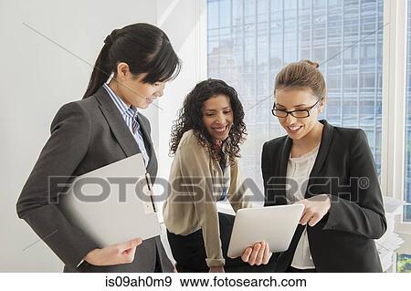 Three businesswomen sharing ideas on digital tablet View Large Photo Image Stock Photo - Three businesswomen sharing ideas on digital tablet. Fotosearch