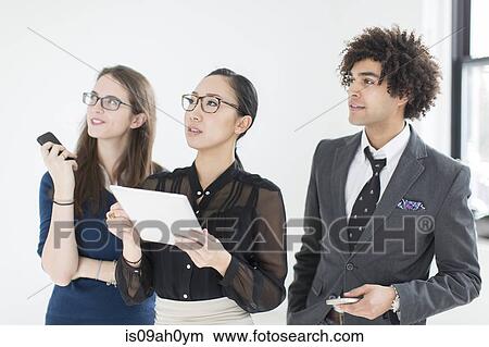 Three colleagues using digital tablet View Large Photo Image Picture - Three colleagues using digital tablet. Fotosearch