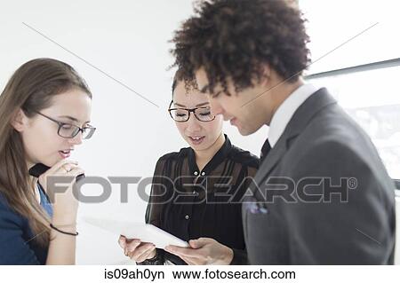 Three colleagues using digital tablet View Large Photo Image Picture - Three colleagues using digital tablet. Fotosearch