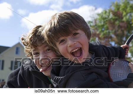 Two brothers sticking out tongues and fooling around View Large Photo Image Picture - Two brothers sticking out tongues and fooling around. Fotosearch