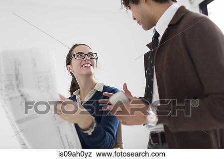 Two colleagues discussing blueprint View Large Photo Image Stock Photo - Two colleagues discussing blueprint. Fotosearch