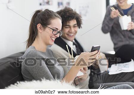 Stock Photo - Two colleagues on lunch break, woman with smartphone. Fotosearch
