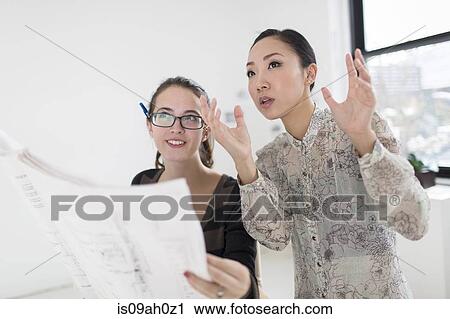 Two female colleagues discussing blueprint View Large Photo Image Stock Image - Two female colleagues discussing blueprint. Fotosearch