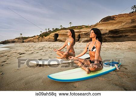 Two surfers, sitting on surfboards on beach, meditating View Large Photo Image Stock Photography - Two surfers, sitting on surfboards on beach, meditating. Fotosearch