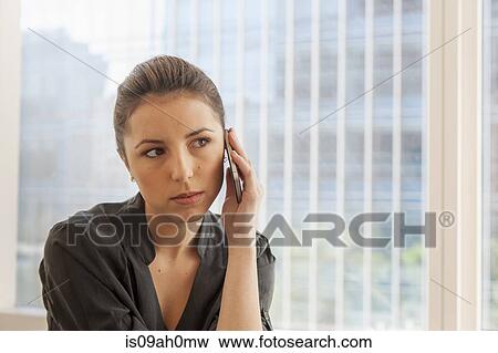 Unhappy businesswoman using cellphone in office View Large Photo Image Stock Photo - Unhappy businesswoman using cellphone in office. Fotosearch
