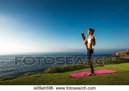 Women on cliff, in yoga position View Large Photo Image Stock Photograph - Women on cliff, in yoga position. Fotosearch