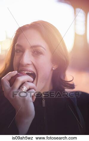 Young businesswoman eating an apple on the street View Large Photo Image Stock Photo - Young businesswoman eating an apple on the street. Fotosearch