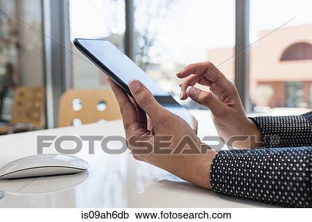 Stock Image - Young businesswoman using digital tablet. Fotosearch