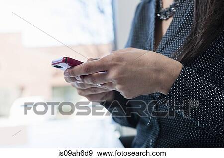 Stock Photo - Young businesswoman using smartphone. Fotosearch