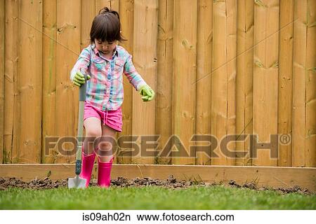 Young girl digging soil in the garden View Large Photo Image Picture - Young girl digging soil in the garden. Fotosearch
