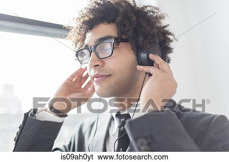 Stock Photograph - Young man wearing headphones. Fotosearch