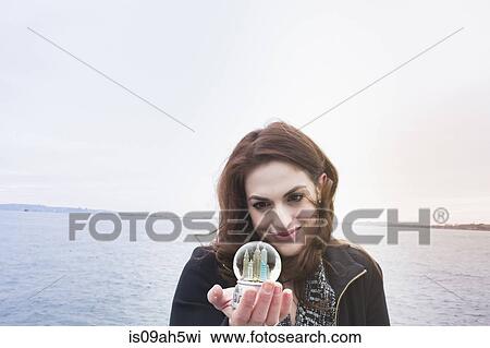 Young woman holding landmark snow globe, New York, USA View Large Photo Image Stock Image - Young woman holding landmark snow globe, New York, USA. Fotosearch