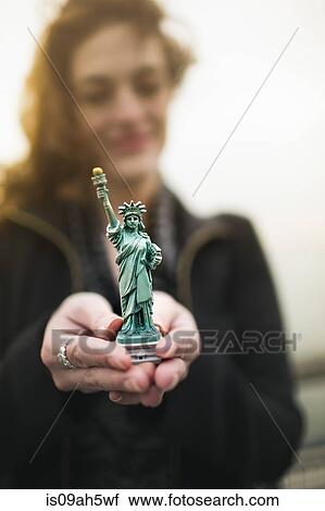Young woman holding statue of liberty souvenir by Hudson river, New York, USA View Large Photo Image Stock Image - Young woman holding statue of liberty souvenir by Hudson river, New York, USA. Fotosearch