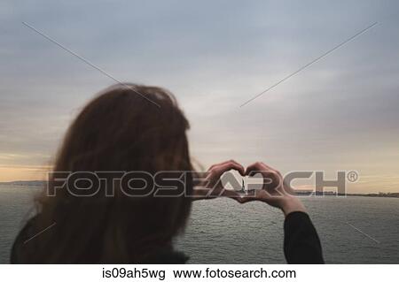 Young woman making heart shape around statue of liberty, New York, USA View Large Photo Image Stock Image - Young woman making heart shape around statue of liberty, New York, USA. Fotosearch