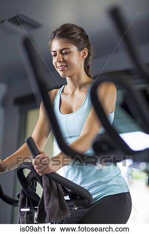 Young woman on cross-trainer View Large Photo Image Stock Photo - Young woman on cross-trainer. Fotosearch