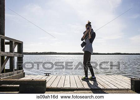 Stock Image - Young woman photographing with digital camera, Richmond, British Columbia, Canada. Fotosearch
