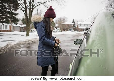 Young woman searching for car keys in her bag View Large Photo Image Stock Image - Young woman searching for car keys in her bag. Fotosearch