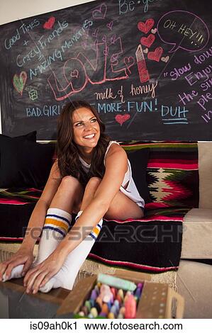Young woman sitting on sofa wearing socks View Large Photo Image Stock Image - Young woman sitting on sofa wearing socks. Fotosearch