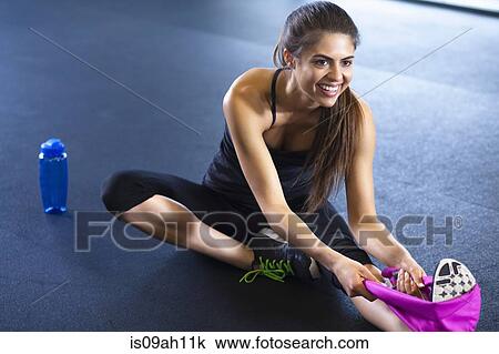 Stock Image - Young woman stretching. Fotosearch