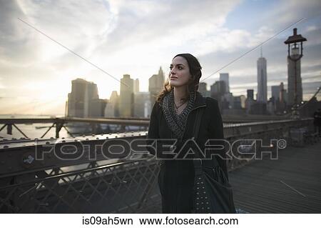 Young woman strolling on Brooklyn bridge, New York, USA View Large Photo Image Picture - Young woman strolling on Brooklyn bridge, New York, USA. Fotosearch