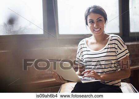 Picture - Young woman using laptop computer. Fotosearch