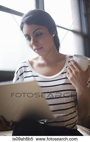 Stock Photography - Young woman using laptop computer. Fotosearch