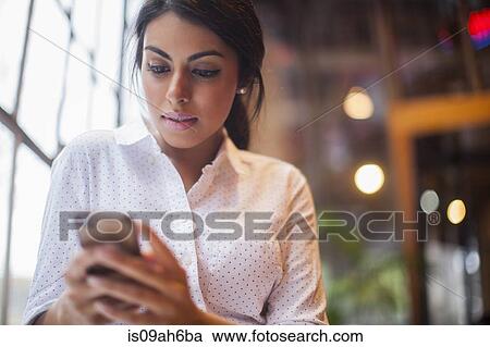 Stock Image - Young woman using smartphone. Fotosearch