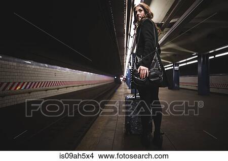 Picture - Young woman waiting in subway station, New York, USA. Fotosearch