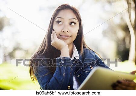 Stock Image - Young woman with chin on hand. Fotosearch
