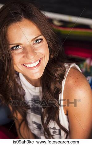 Stock Image - Young woman with long brown hair smiling. Fotosearch