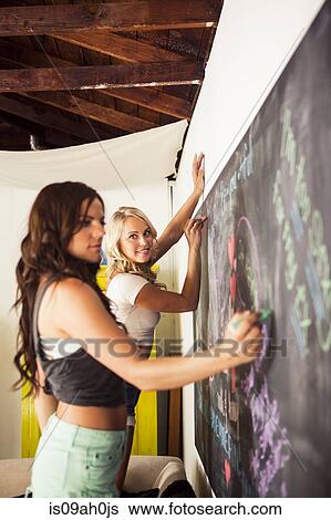 Young women drawing on blackboard View Large Photo Image Stock Photograph - Young women drawing on blackboard. Fotosearch