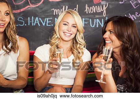 Young women holding champagne glasses View Large Photo Image Stock Photography - Young women holding champagne glasses. Fotosearch