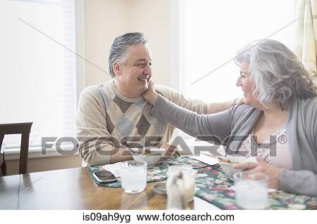 Affectionate mature adult couple having lunch at home View Large Photo Image Stock Image - Affectionate mature adult couple having lunch at home. Fotosearch