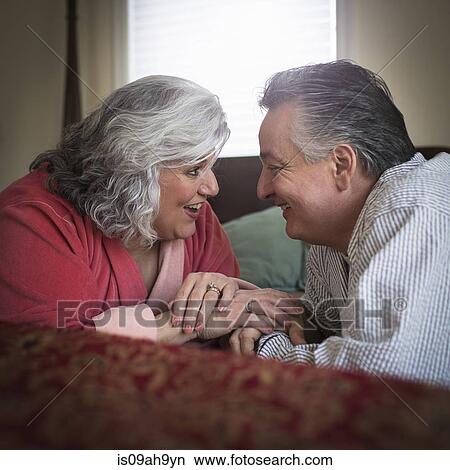 Affectionate mature adult couple lying on bed View Large Photo Image Picture - Affectionate mature adult couple lying on bed. Fotosearch