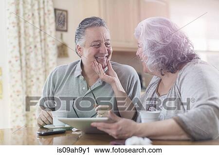 Affectionate mature adult couple sharing breakfast at home View Large Photo Image Stock Image - Affectionate mature adult couple sharing breakfast at home. Fotosearch