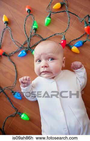 Baby lying on floor surrounded by christmas lights View Large Photo Image Stock Image - Baby lying on floor surrounded by christmas lights. Fotosearch