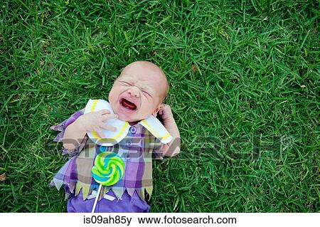 Baby lying on grass, crying View Large Photo Image Stock Photo - Baby lying on grass, crying. Fotosearch