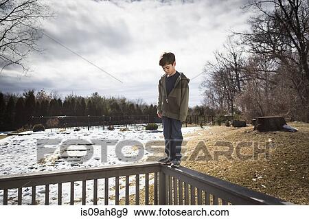 Boy balancing on top of fence in park View Large Photo Image Stock Photo - Boy balancing on top of fence in park. Fotosearch