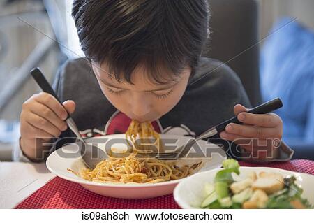 Stock Image - Boy eating spaghetti. Fotosearch