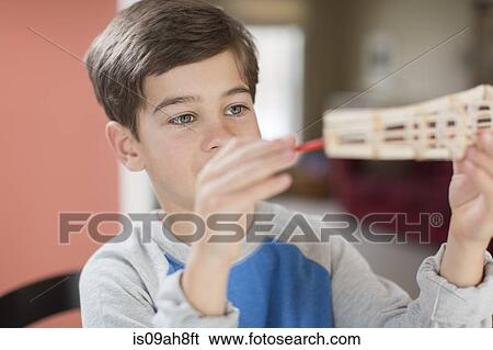 Boy holding up handmade model View Large Photo Image Stock Photograph - Boy holding up handmade model. Fotosearch