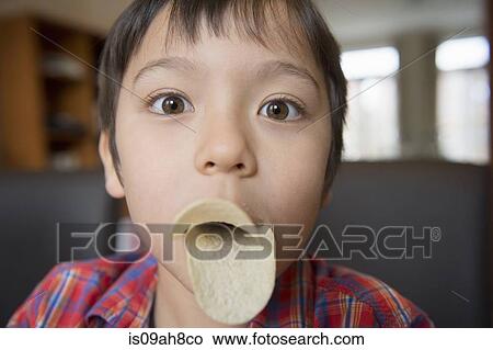 Picture - Boy imitating bird beak with crisps. Fotosearch