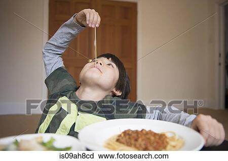 Stock Image - Boy playing with spaghetti. Fotosearch
