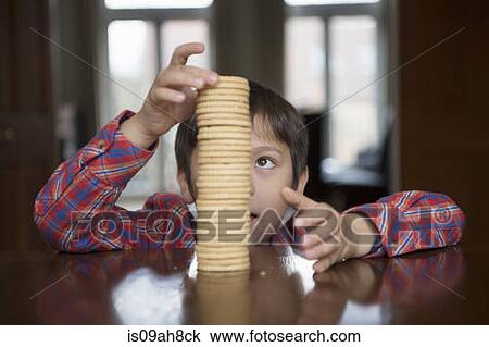 Stock Image - Boy stacking up biscuits. Fotosearch
